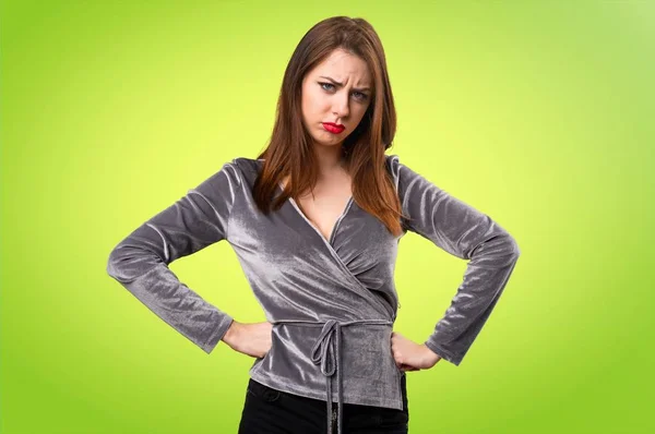 Sad beautiful young girl on colorful background — Stock Photo, Image