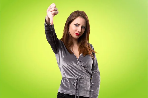 Hermosa chica joven haciendo mala señal en el fondo colorido — Foto de Stock