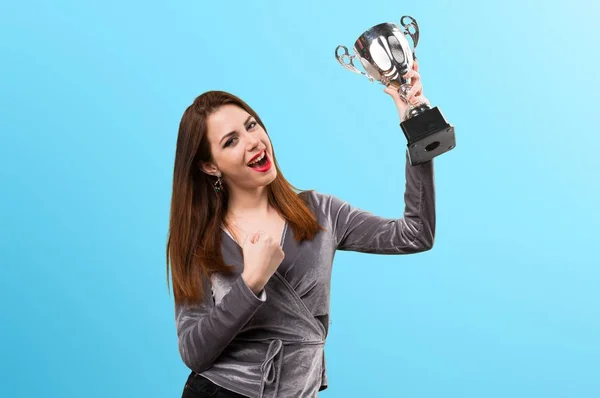 Bella ragazza in possesso di un trofeo su sfondo colorato — Foto Stock