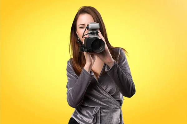 Mooi jong meisje filmen op kleurrijke achtergrond — Stockfoto