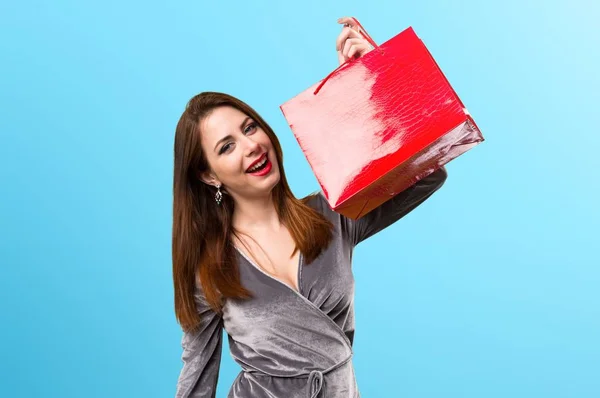 Menina bonita com saco de compras no fundo colorido — Fotografia de Stock