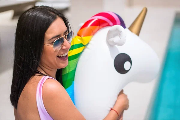 Hermosa joven con flotador unicornio —  Fotos de Stock