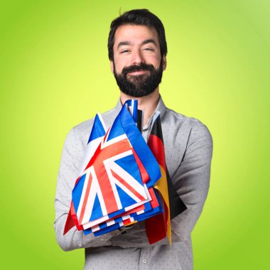 Birçok bayrak tutan sakallı yakışıklı adam