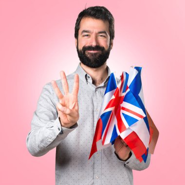 Birçok bayrak tutan ve üç sayım sakallı yakışıklı adam