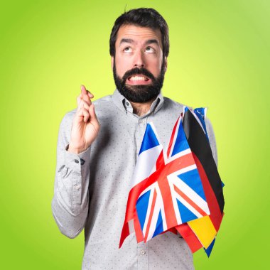 Yakışıklı adam birçok bayrak tutan sakallı ve elleriyle dokunuyor 