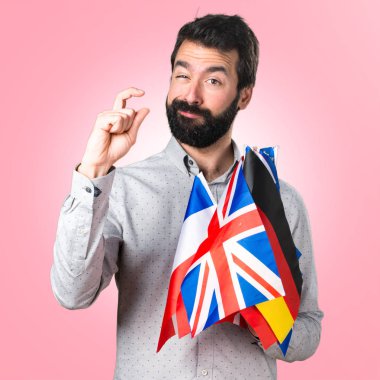 Birçok bayrak tutan ve küçük işareti yaparak sakallı yakışıklı adam