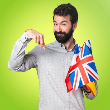 Birçok bayrak tutan ve aşağı dönük sakallı yakışıklı adam