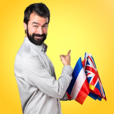 Birçok bayrak tutan ve geri işaret sakallı yakışıklı adam