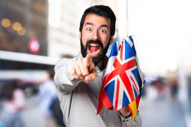 Birçok bayrak tutan ve f için işaret sakallı yakışıklı adam