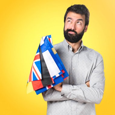 Birçok bayrak tutan ve düşünme sakallı yakışıklı adam