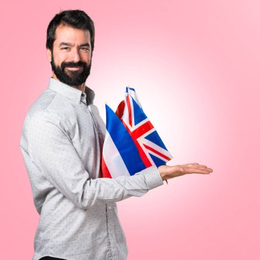 Birçok bayrak tutan ve içecek sunma sakallı yakışıklı adam