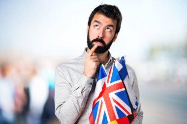 Birçok bayrak tutan ve düşünme sakallı yakışıklı adam