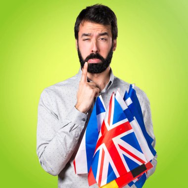 Birçok bayrak tutan sakallı üzgün yakışıklı adam