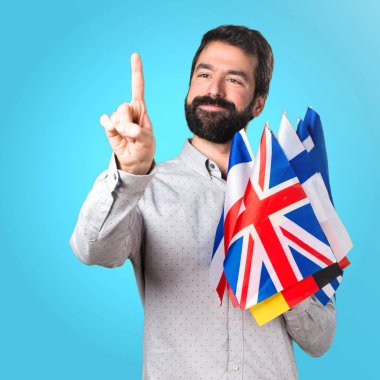 Birçok bayrak tutan ve trans üzerinde dokunmadan sakallı yakışıklı adam