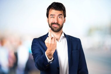 Yakışıklı adam yapma boynuz jest odaklanmamış arka plan üzerinde