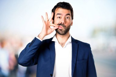 Yakışıklı adam yapma sessizlik jest odaklanmamış arka plan üzerinde