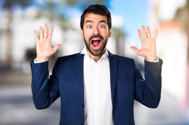 Yakışıklı adam yapma sürpriz jest odaklanmamış arka plan üzerinde