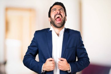 Yakışıklı adam odaklanmamış arka plan üzerine bağırarak