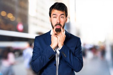 Odaklanmamış arka plan üzerinde üzgün yakışıklı adam