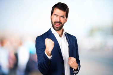 Odaklanmamış arka plan üzerinde şanslı yakışıklı adam