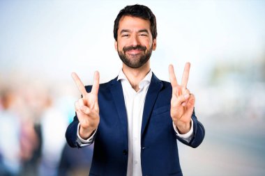 Yakışıklı adam yapma zafer jest odaklanmamış arka plan üzerinde