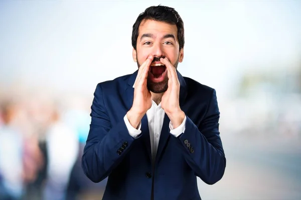Pohledný muž křičí na nezaostřený pozadí — Stock fotografie