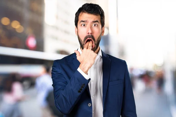 Handsome man making vomiting gesture on unfocused background — Stock Photo, Image