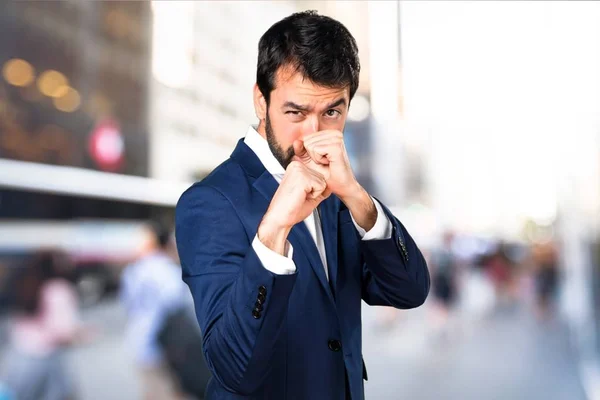 Handsome man giving a punch on unfocused background — Stock Photo, Image