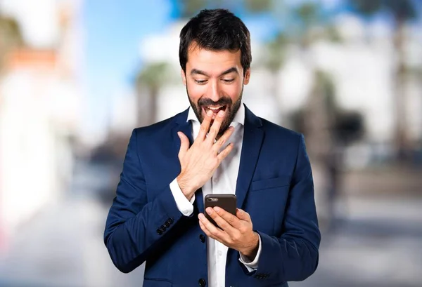 Schöner Mann spricht mit Handy auf unfokussiertem Hintergrund — Stockfoto