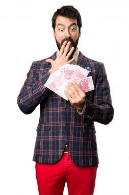 Sürpriz iyi giyimli adam beyaz arka plan üzerinde bir sürü para alarak