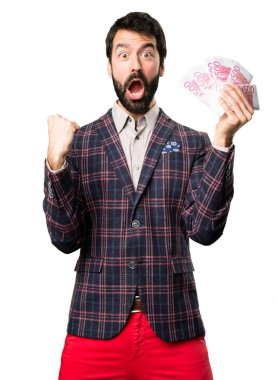 Sürpriz iyi giyimli adam beyaz arka plan üzerinde bir sürü para alarak