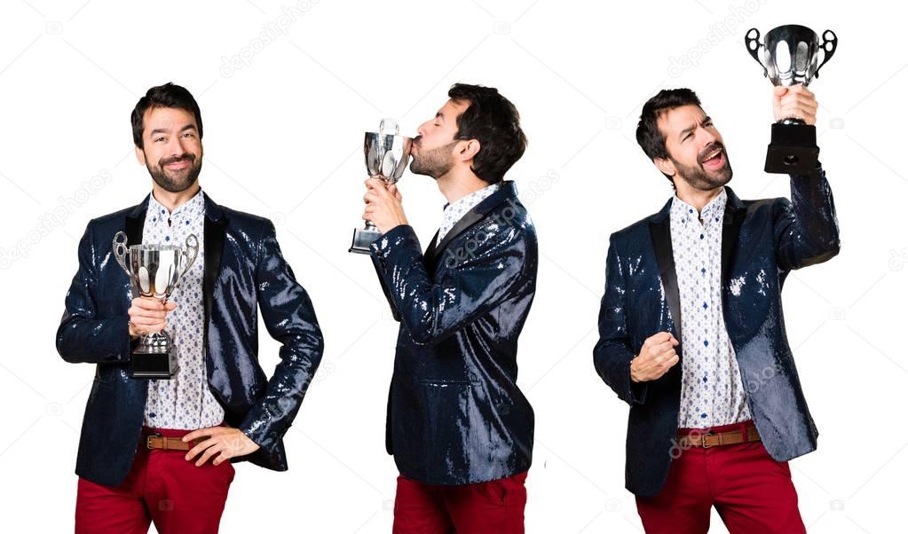 Man with jacket holding a trophy