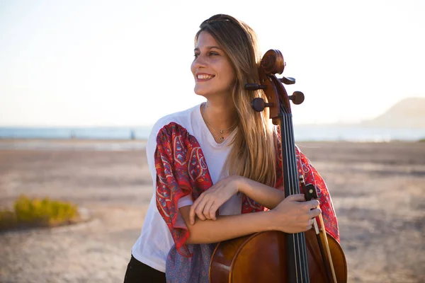 Jovem menina bonita feliz com seu violoncelo no exterior — Fotografia de Stock