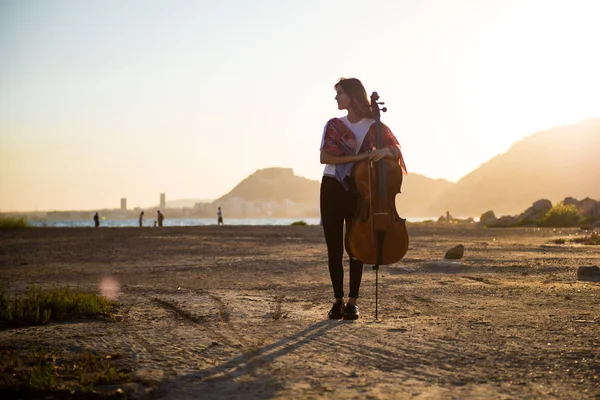 Jovem menina bonita com seu violoncelo no exterior — Fotografia de Stock