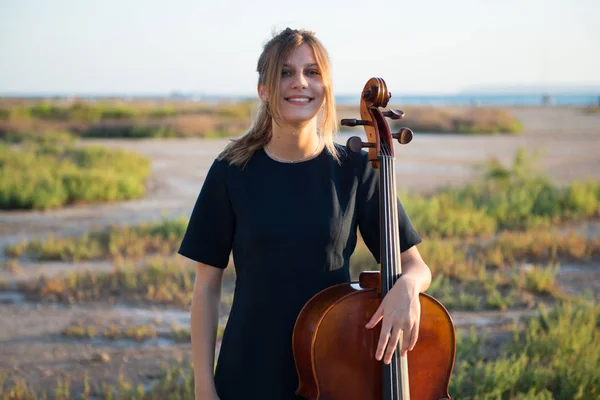 Jovem menina bonita feliz com seu violoncelo no exterior — Fotografia de Stock