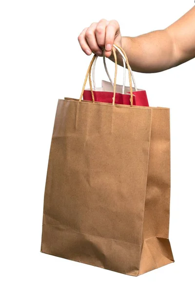 Mano sosteniendo bolsa de compras sobre fondo blanco aislado — Foto de Stock