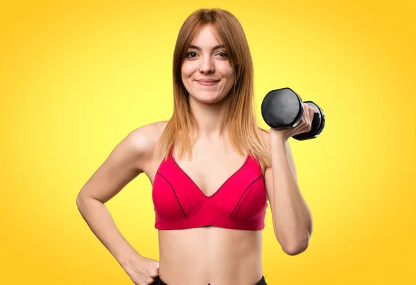 Feliz hermosa mujer del deporte con mancuernas en el fondo colorido —  Fotos de Stock