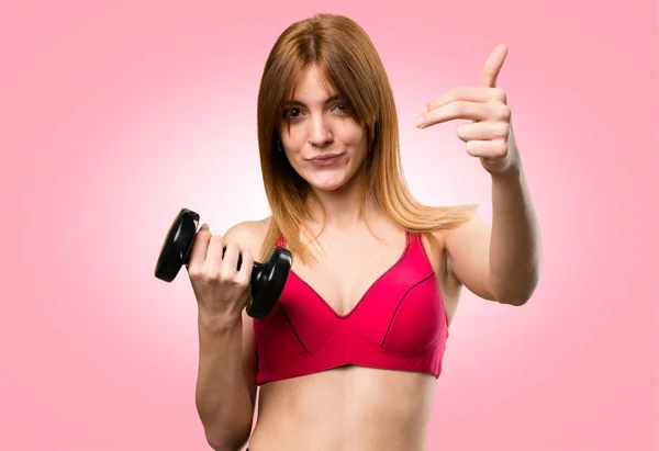 Beautiful sport woman with dumbbells doing coming gesture on col — Stock Photo, Image