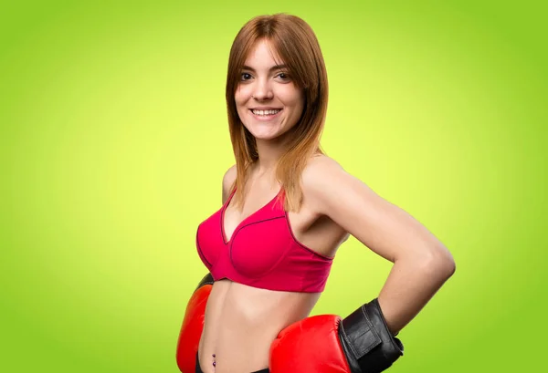Jovem mulher esporte com luvas de boxe no fundo colorido — Fotografia de Stock