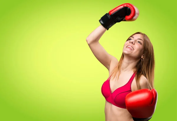 Giovane donna sportiva con guanti da boxe su sfondo colorato — Foto Stock