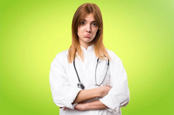 Triest jonge dokter vrouw op kleurrijke achtergrond — Stockfoto