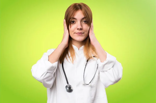 Jonge dokter vrouw die betrekking hebben op haar oren op kleurrijke achtergrond — Stockfoto