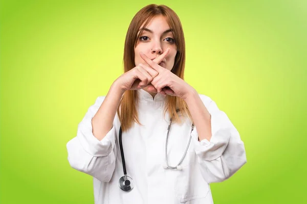 Jonge dokter vrouw maken stilte gebaar op kleurrijke achtergrond — Stockfoto