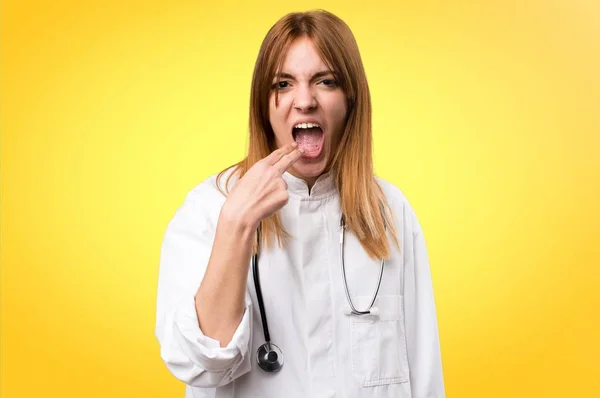 Молода лікарка робить жест блювоти на барвистому фоні — стокове фото