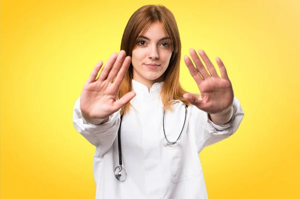 Jonge dokter vrouw stopbord op kleurrijke achtergrond maken — Stockfoto