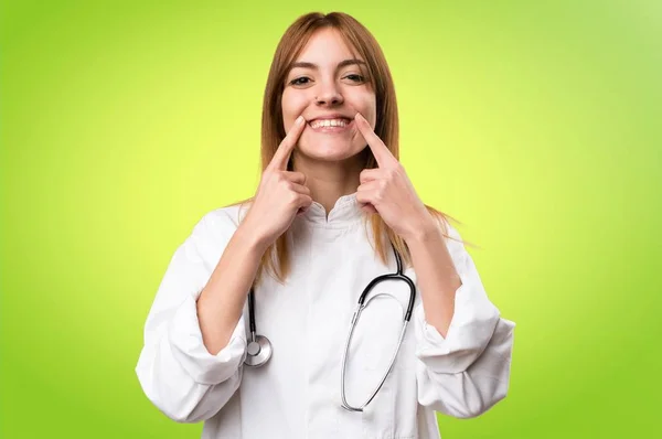 Heureuse jeune femme médecin sur fond coloré — Photo