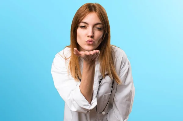 Giovane medico donna invio di un bacio su sfondo colorato — Foto Stock