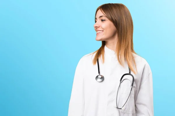 Jonge dokter vrouw op zoek laterale op kleurrijke achtergrond — Stockfoto