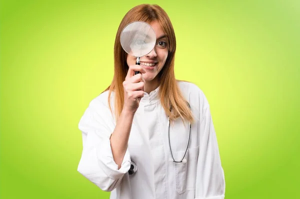 Jonge dokter vrouw met vergrootglas op kleurrijke achtergrond — Stockfoto