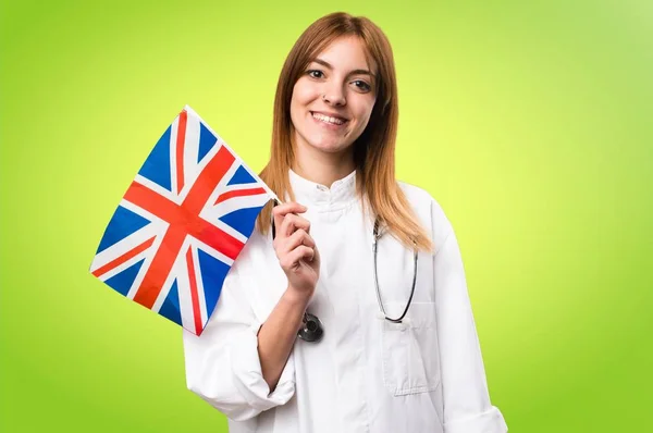 若い医者のカラフルな背景に英国のフラグを保持している女性 — ストック写真